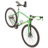 Green cyclocross bike suspended by saddle horn from Velo Wall Post in studio setting.