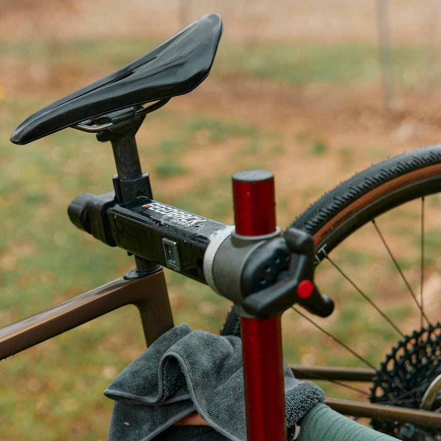 Close up of bike repair stand clamp jaw arm with bike mounted in use outdoors.