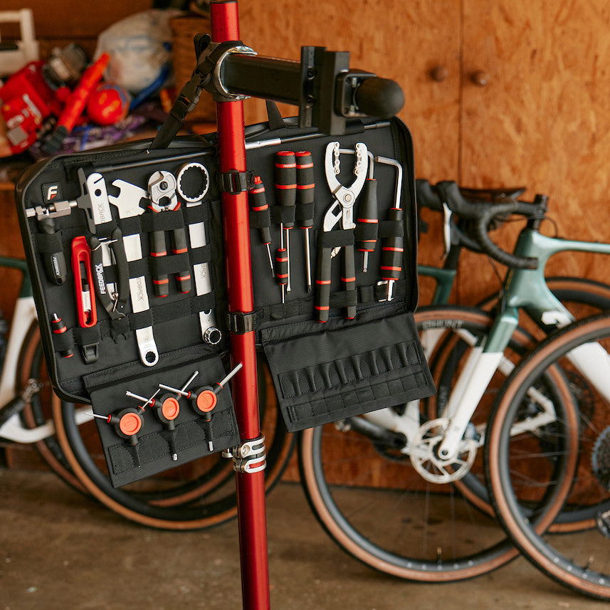 Bike repair tool kit installed on a bike work stand in a garage setting.