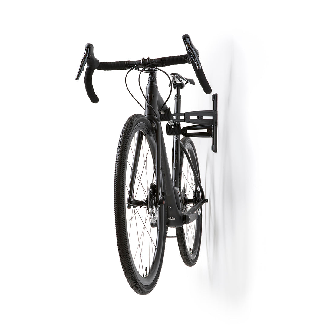 Black road bike viewed from head-on, suspended on wall mounted bike storage cradle arms.
