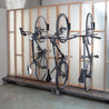 Three bikes on Velo Hinge bike hooks hung from 2x4 stud framed wall.
