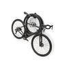 Black road bike and 2 bike wheels suspended from Velo Wall post bike storage arm in studio.