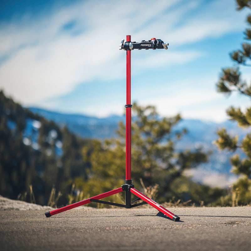 Feedback Sports Pro Mechanic bike repair stand deployed for use outdoors in a mountain setting.