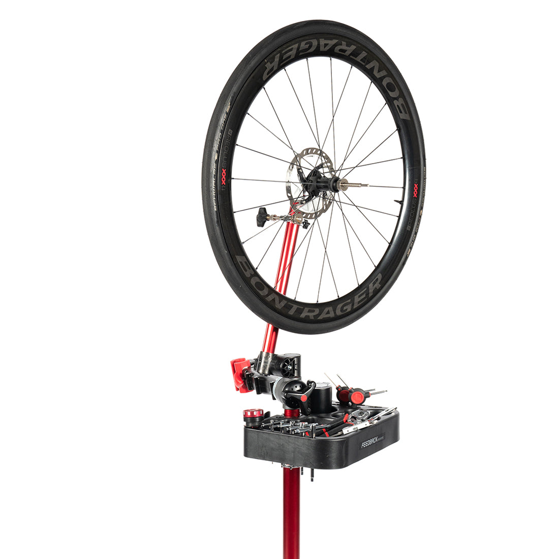 Bike wheel truing stand mounted on a bike repair stand with tool tray and wheel installed.