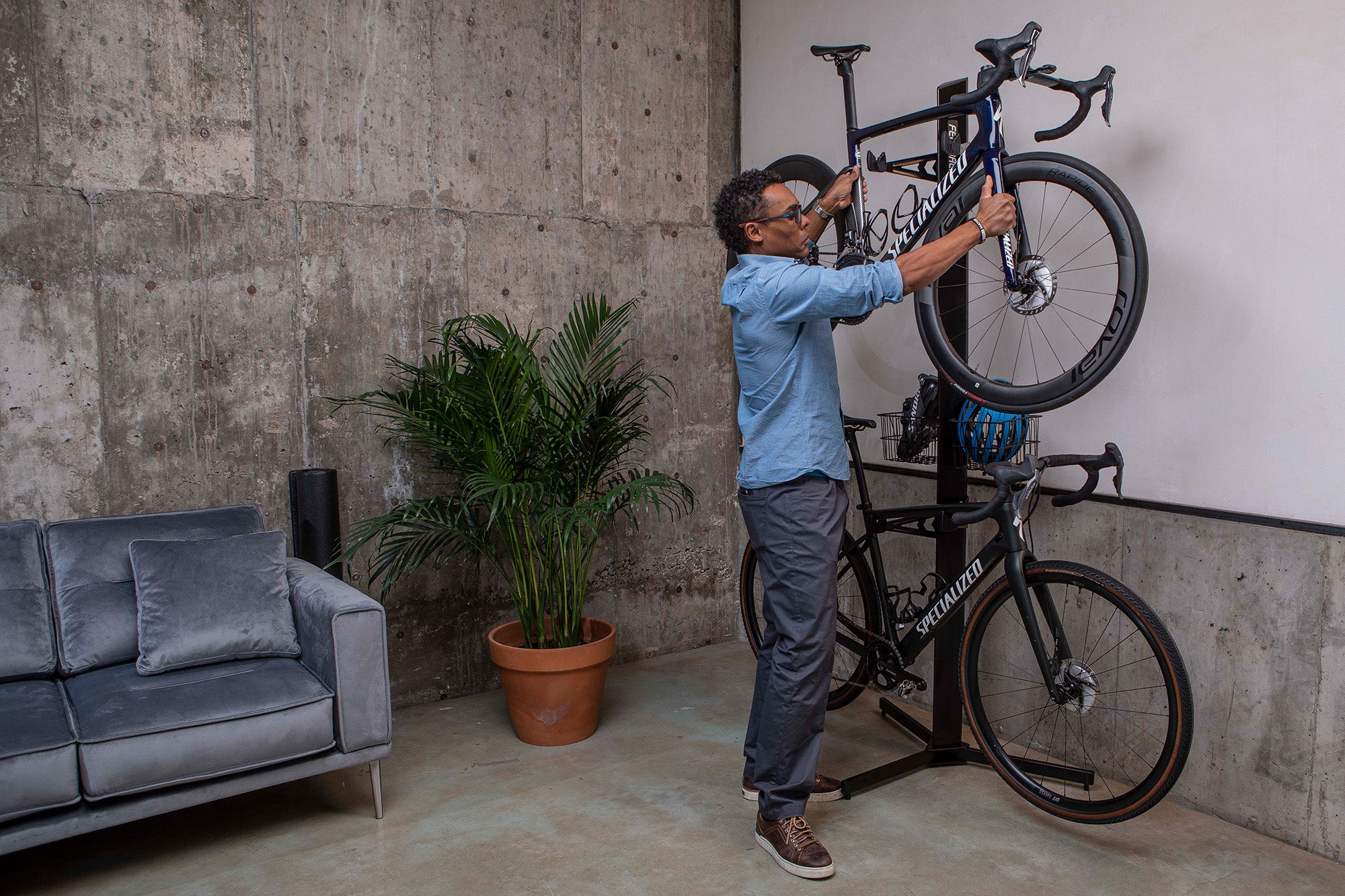 man putting his bike on the velo cache storage solution in his apartment.