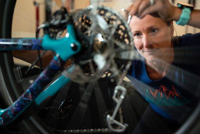 Woman working on a bicycle in a shop.