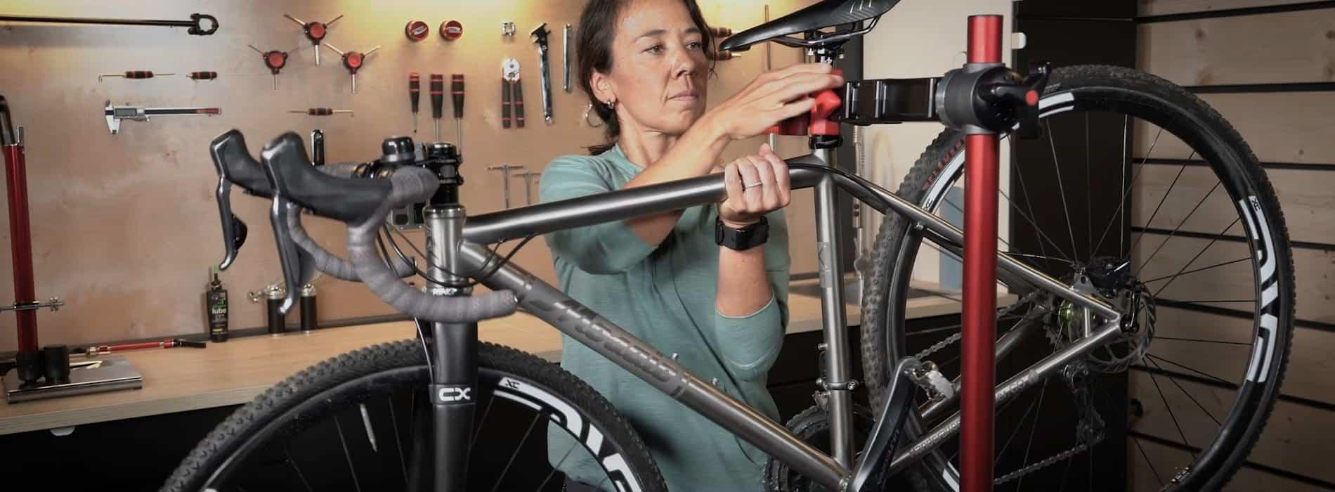 Woman fixing bicycle in a bike shop.