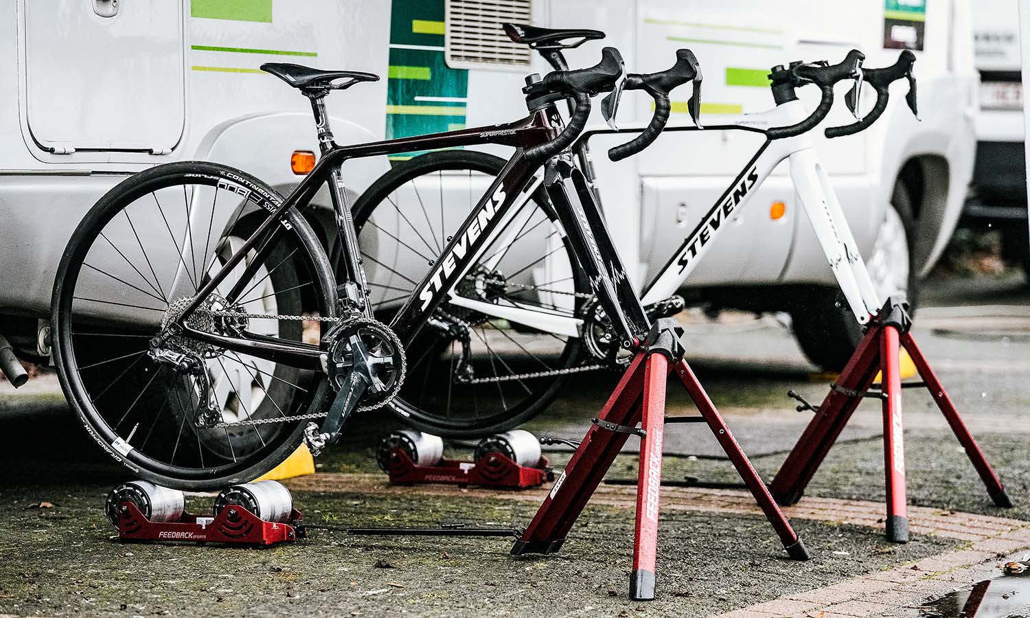 bikes mounted on stationary trainers near team truck