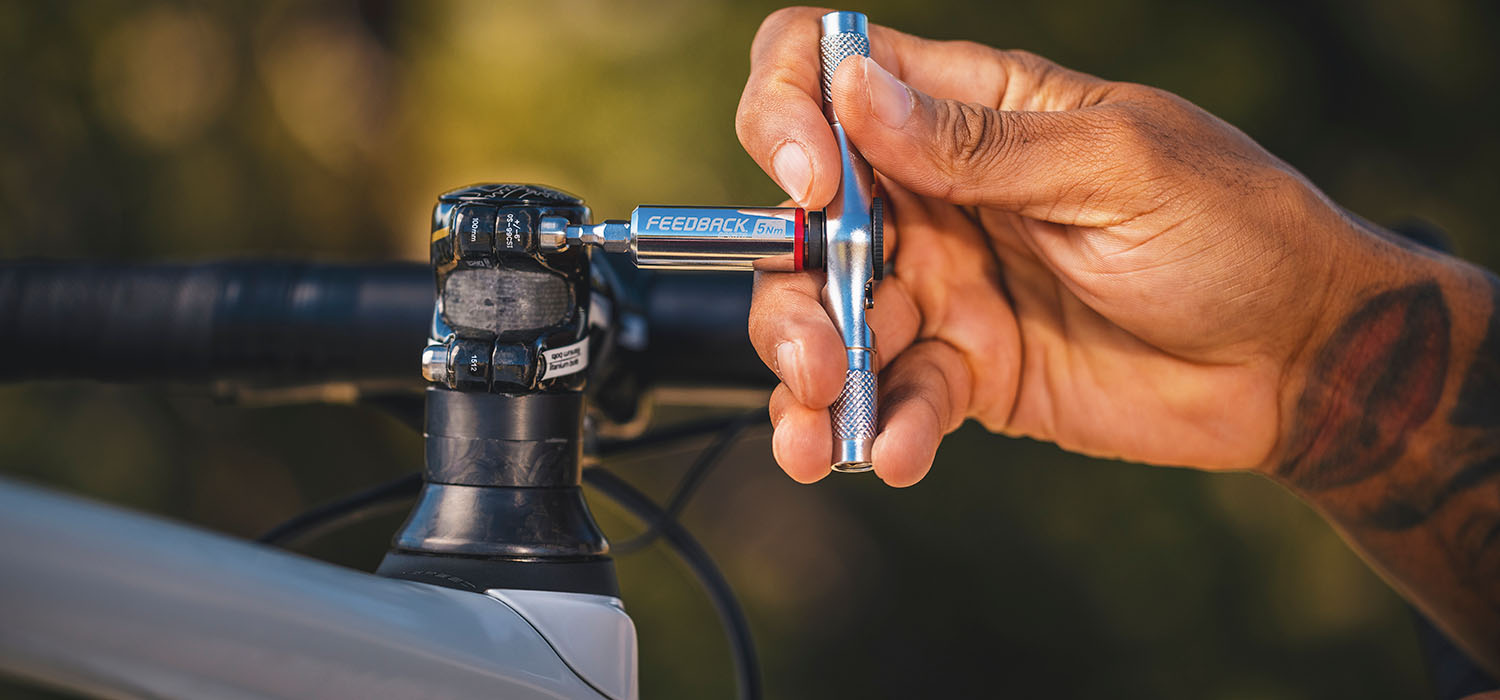 Close up of hand holding bike tool fixing a bike.